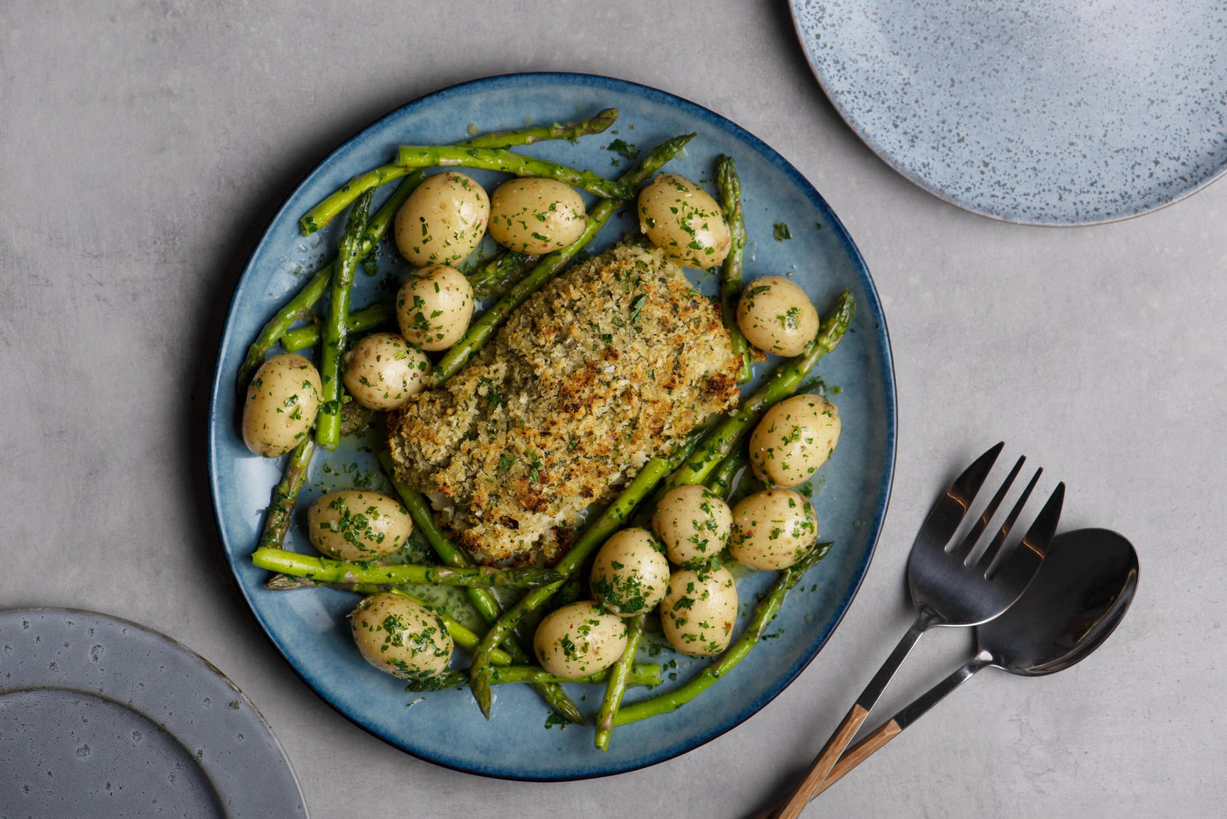 Cod loin baked with a lemon and herb crust, buttery new potatoes and asparagus